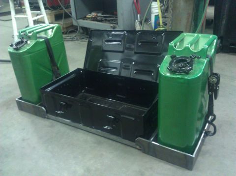 1979 Ford Bronco - A custom metal frame holds two green jerry cans and an open black toolbox, likely for off-road or utility vehicle modification.