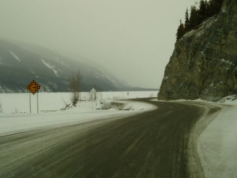 2009 Kenworth T800 - Driving on a slippery road through a winter landscape with mountains and a frozen lake.