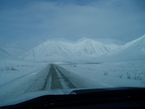 2009 Kenworth T800 - Driving through a vast, snow-covered mountain range under a cloudy sky.