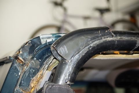1995 Ford Bronco - Close-up view of a damaged and rusted vehicle roll bar and frame.