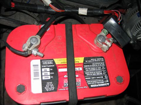 1992 Ford Bronco - Close-up view of a vehicle's battery, showing its terminals and wiring connections.