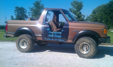 1987 Ford Bronco - Side view of a 1987 Ford Bronco, showing "RE Construction Co." and phone number on the door.