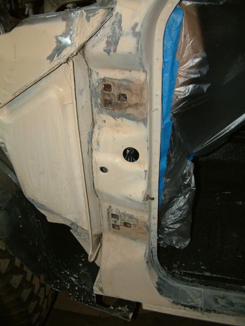 1983 Ford Bronco - The door jamb of a 1983 Ford Bronco shows body filler and masking tape, indicating repair work is in progress.