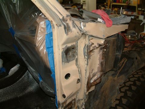 1983 Ford Bronco - Vehicle body undergoing repair work, showing exposed metal and protective coverings.