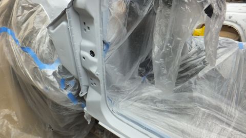 1983 Ford Bronco - The interior of a vehicle is covered in plastic and tape, preparing for a paint job.