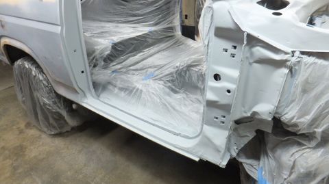 1983 Ford Bronco - The interior of a white Ford Bronco is covered in plastic sheeting during a restoration process.