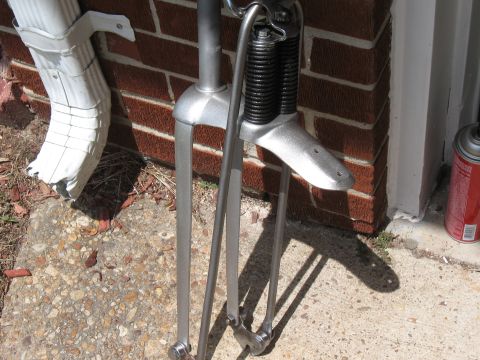 1994 Ford Bronco - A bicycle fork assembly is shown in detail, with a downspout and brick wall in the background.
