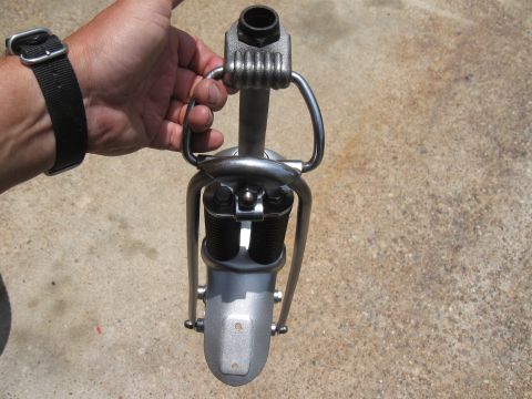 1994 Ford Bronco - Close-up of a motorcycle front suspension part being held by a hand.