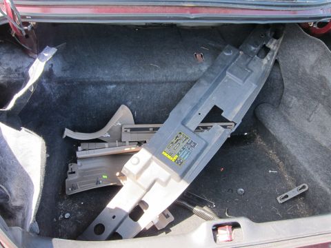 2001 Ford Crown Victoria - The trunk of a 2001 Ford Crown Victoria contains a fuse box cover and other disassembled components.