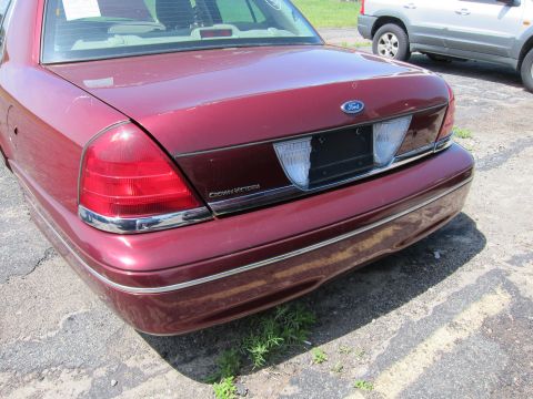 2001 Ford Crown Victoria - Rear view of a maroon 2001 Ford Crown Victoria, with another vehicle visible in the background.