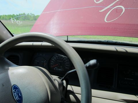 2001 Ford Crown Victoria - Interior view of a 2001 Ford Crown Victoria with the hood open, showing the dashboard and steering wheel.