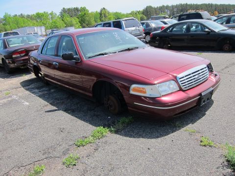 2001 Ford Crown Victoria - Maroon 2001 Ford Crown Victoria, missing its wheels, sits in an outdoor lot.