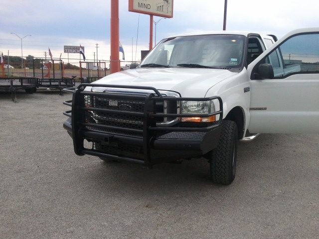 White Ford F-series truck with black brush guard and driver's door open
