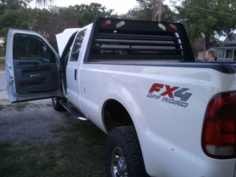 2004 Ford F-350 - This white Ford F-350 FX4 Off Road pickup truck has its doors open and hood up, parked outdoors.