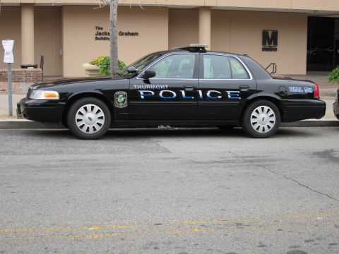 1991 Ford LTD Crown Victoria - Side view of a black Thurmont Police Ford Crown Victoria sedan parked outside an office building.