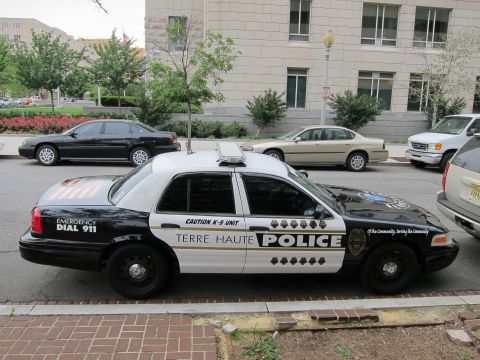 1991 Ford LTD Crown Victoria - Driver-side view of a black-and-white Terre Haute Police Ford Crown Victoria K-9 cruiser on a city street.