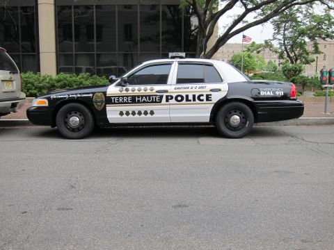 1991 Ford LTD Crown Victoria - Full driver-side profile of a black-and-white Terre Haute Police Ford Crown Victoria K-9 cruiser parked on pavement.