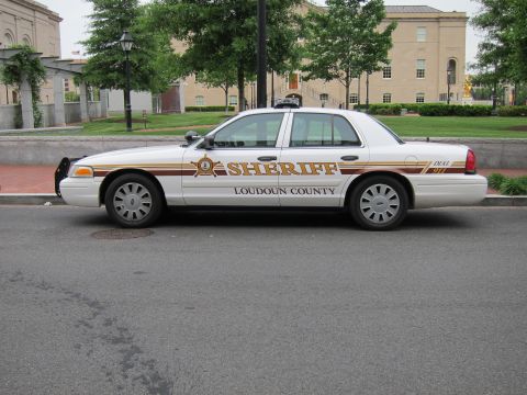 1991 Ford LTD Crown Victoria - white Ford Crown Victoria sheriff sedan marked Loudoun County parked on a street beside a stone building.