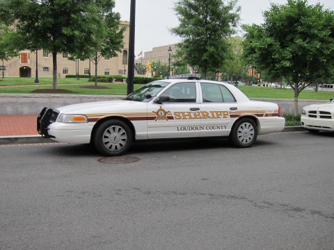 1991 Ford LTD Crown Victoria - white Loudoun County Sheriff Ford Crown Victoria sedan parked along a street with trees and lawn behind.