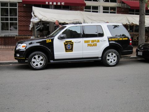 1991 Ford LTD Crown Victoria - black-and-white Ford Explorer marked West Mifflin Police, unit 254, parked at a curb in front of a restaurant.