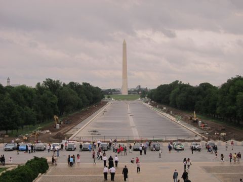 1991 Ford LTD Crown Victoria - View toward the Washington Monument over an empty reflecting pool under construction, with parked cars and crowds below.
