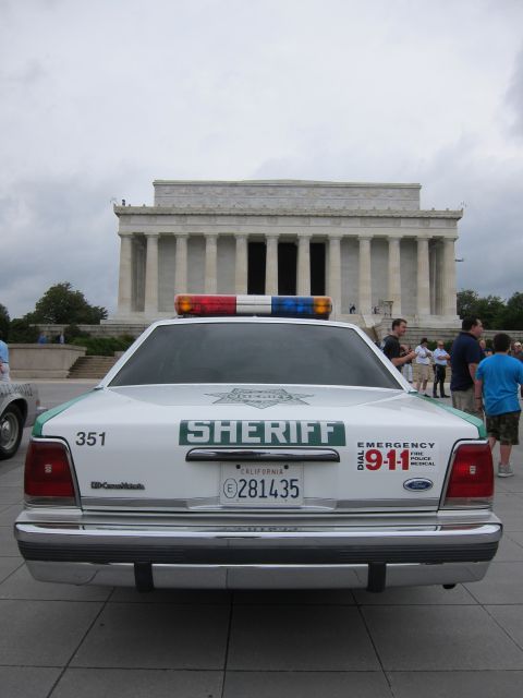 1991 Ford LTD Crown Victoria - Rear view of a white-and-green Ford Sheriff car marked 351 and 911, parked in front of the Lincoln Memorial.