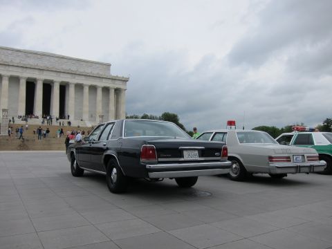 1991 Ford LTD Crown Victoria - dark blue Ford sedan parked on the plaza in front of the Lincoln Memorial alongside other vintage police cars.