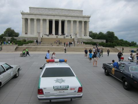1991 Ford LTD Crown Victoria - white SHERIFF cruiser with light bar parked facing the Lincoln Memorial as visitors walk on the plaza.