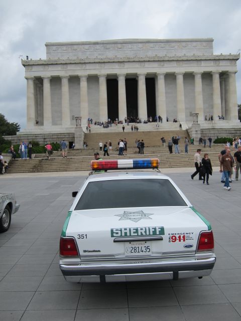 1991 Ford LTD Crown Victoria - green-and-white SHERIFF Ford Crown Victoria parked facing the Lincoln Memorial as people climb the steps.