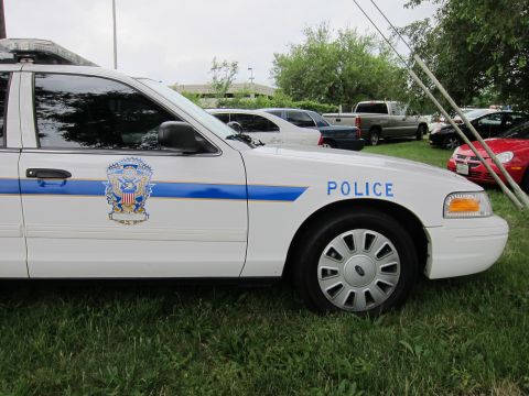 1991 Ford LTD Crown Victoria - Close-up of a white police sedan door showing a blue stripe, eagle crest emblem and Police lettering.