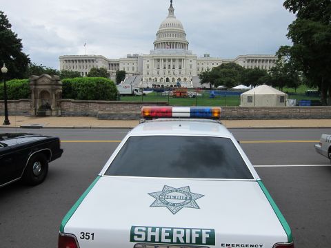 1991 Ford LTD Crown Victoria - Low rear view of a green-and-white Sheriff patrol car parked on a street with the U.S. Capitol dome behind it.