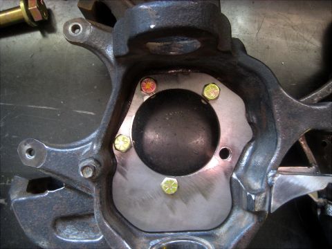 1996 Ford Bronco - Close-up of a vehicle's steering knuckle assembly with hardware.