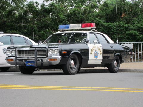 1991 Ford LTD Crown Victoria - black-and-white highway patrol cruiser with a chrome brush guard and roof light bar parked along a curb.
