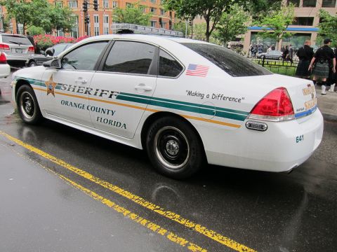 1991 Ford LTD Crown Victoria - white Orange County Florida Sheriff sedan with green and gold striping and a star emblem, seen from the rear.