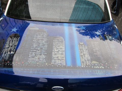 1991 Ford LTD Crown Victoria - Airbrushed hood of a blue Ford depicting an illuminated city skyline at night with twin beams of light rising from the buildings.