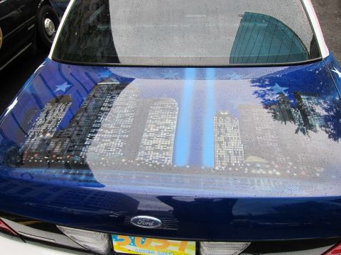 1991 Ford LTD Crown Victoria - Trunk lid of a blue Ford with an airbrushed nighttime skyline, a vertical blue light beam and white stars on the surrounding paint.