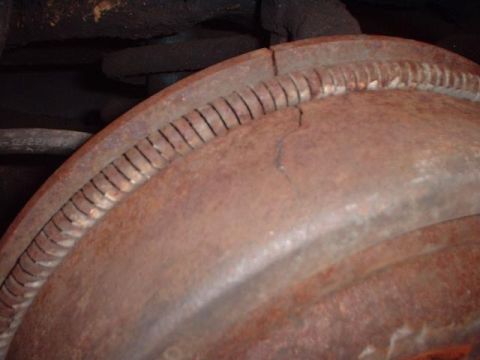 1996 Ford Taurus - A heavily rusted brake drum shows a crack and a ribbed edge, indicating wear and potential damage.