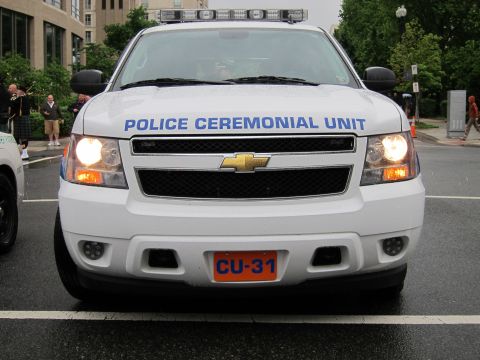 1991 Ford LTD Crown Victoria - Head-on view of a white Chevrolet SUV with a light bar marked Police Ceremonial Unit and an orange front plate reading CU-31.