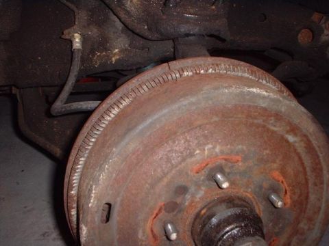 1996 Ford Taurus - Rusty brake drum and suspension components are shown in this close-up view.