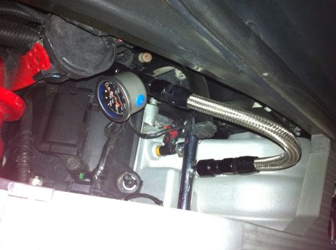 2010 Dodge Challenger - A close-up shows a throttle body assembly with a pressure gauge and braided fuel line attached.