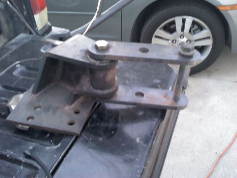 1979 Ford F-150 - Close-up of a metal bracket with bolts and bushings, likely a vehicle part.