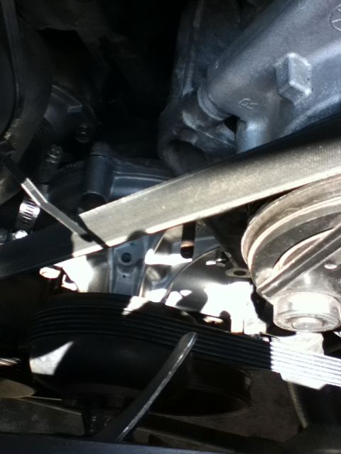 1994 Ford Bronco - Close-up view of the engine's water pump, pulley, and serpentine belt system.