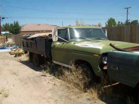 1965 Ford 427 - This green flatbed truck appears to be a work in progress, parked outdoors with various items in its bed.