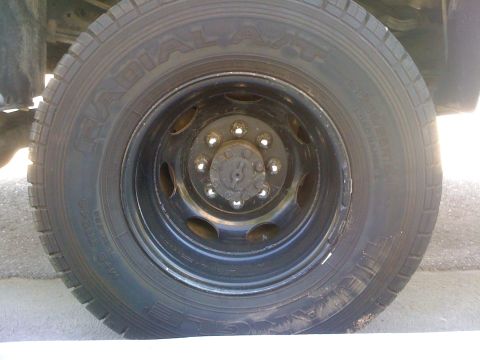 1997 Dodge 3500 - Close-up of a truck's wheel and tire, showing the radial tread pattern and black rim.