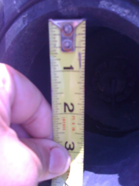 1997 Dodge 3500 - A tape measure is used to measure the interior depth of a dark-colored rim.