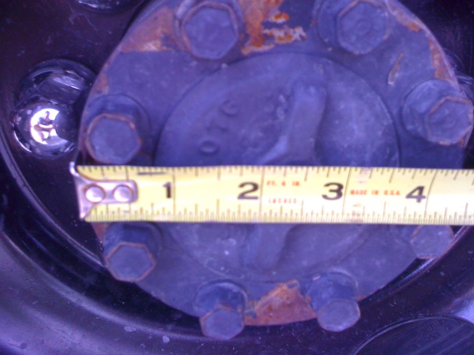 Close-up of a wheel hub with a measuring tape showing approximately 3 inches