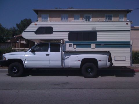 1997 Dodge 3500 - This 1997 Dodge 3500 pickup truck is equipped with a large camper shell, extending its utility for travel and accommodation.