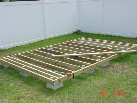 2000 Ford Crown Victoria - Deck framing is assembled on concrete blocks in a backyard setting.