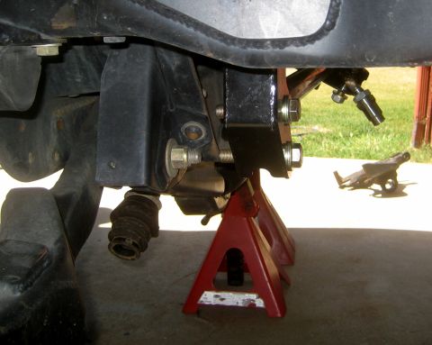 1996 Ford Bronco - Close-up view of vehicle suspension components supported by jack stands.