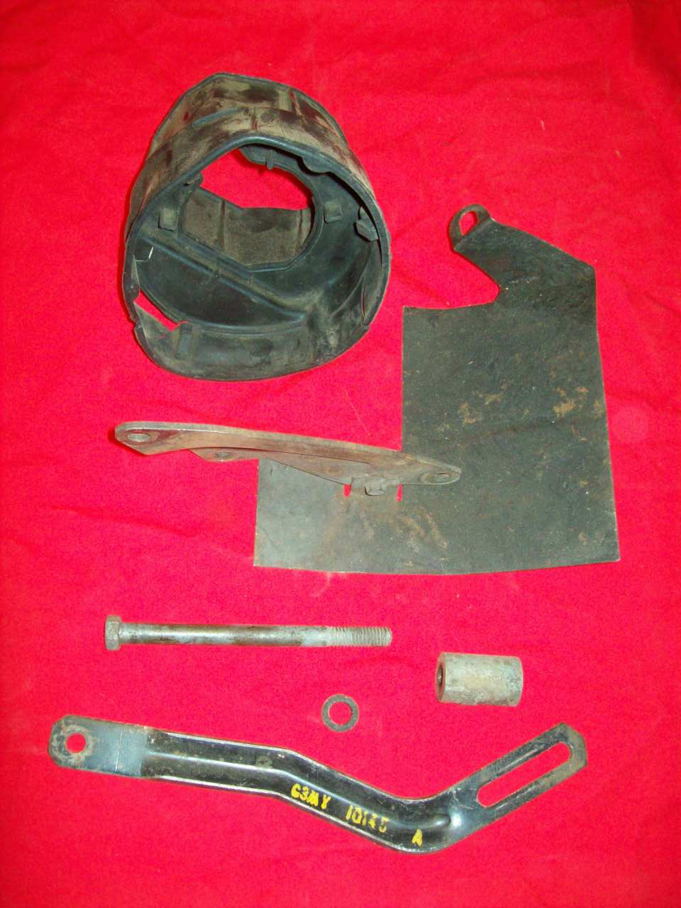 Assorted engine parts including a black air intake duct and metal brackets